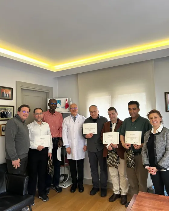 Visiting surgeons holding training certificates with Prof. Dr. Mustafa Yüksel at his clinic in Istanbul